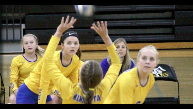 As McKenna Yost set the ball for Minneota, hitter Natalee Rolbiecki (seen between Yost's arms) was poised and ready to hit the ball. Abby Rost (right) was also watching in case she got the set — and also watching was McKenzie Tolk (left) and Coach Hayley Fruin (right).