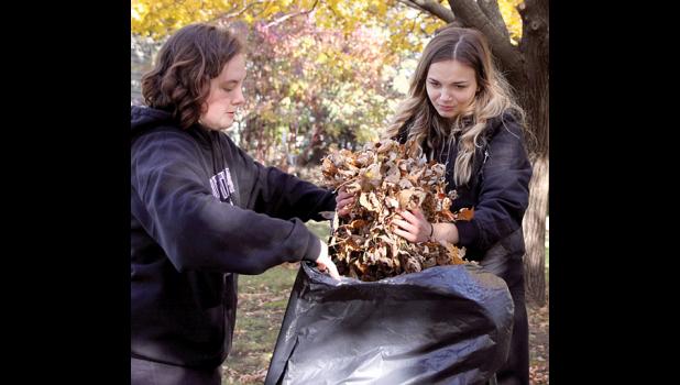 Staff Photo by Byron Higgin. Reagan Bierschenk and Kadynce Sanoski bagged leaves after raking them at the Gayle VanVooren home.