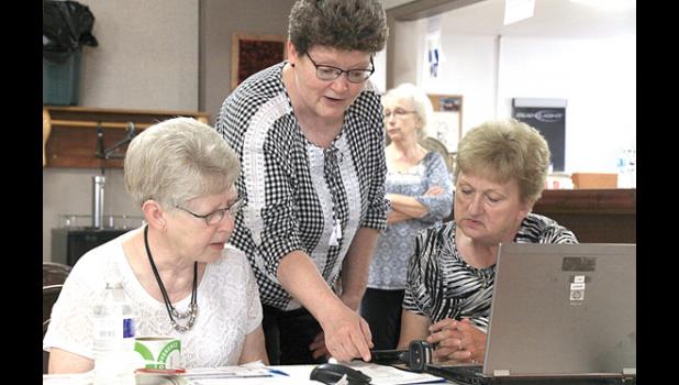 Staff Photo by Byron Higgin. Barb Okrina (center), working with helpers Brenda Verschelde (left) and Kathy Wyffels.