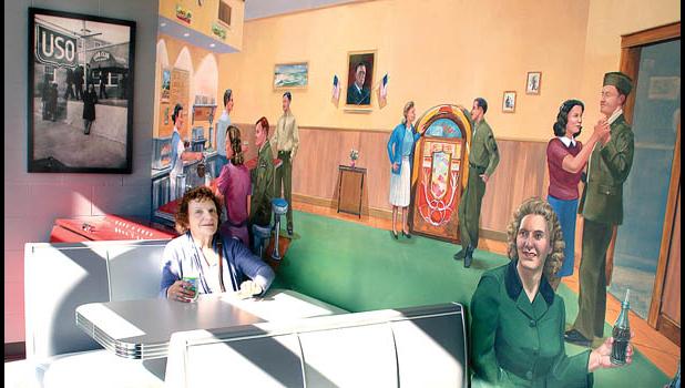Staff Photo by Byron Higgin. The painting of the old malt shop on a wall at the Ray Fagen World War II Museum was the perfect place to transport my sister Caryn Chilton (left), of the Portland, OR area.