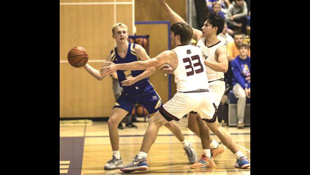 Mascot photo by Brian Jeremiason Max Rost, left, of Minneota looks for an open teammate to pass to while being guarded by two Yellow Medicine East players last Thursday in Minneota.
