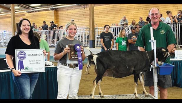 Contributed photo Brooke Moorse, center, and her award winning dairy goat Flirtini, received a brand new goat fitting and milking stand for winning the Minnesota 4-H Dairy Goat Best in Show Senior Doe on Friday. This award is sponsored by the Synder family, Elizabeth (Synder) Lange, left, Marc Synder, right, and Pamela Synder (not pictured) of Buffalo Lake.