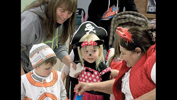 Staff photo by Byron Higgin Joni Pesch gave candy to kids with Cheryl Nuese helping out as well.