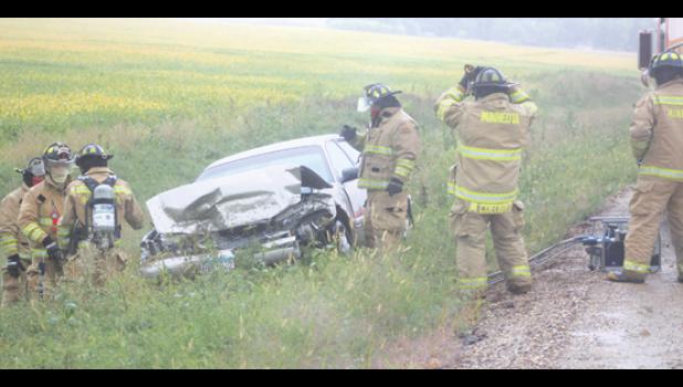 Staff photo by Scott Thoma. Several members of the Minneota Fire Department, as well as First Responders and the Lyon County Sheriff's Department responded to a smashed vehicle in the ditch on the west side of County Road 3 just outside of Minneota in the rain on Monday.