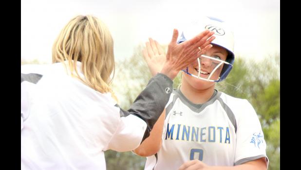 Staff Photo by Byron Higgin. Sydney Larson was congratulated by Coach Heidi Boerboom after she hit a home run in the 9-4 playoff-opening win over Montevideo Thursday.