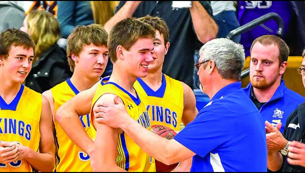 Photo by Brian Jeremiason. Thomas Hennen received congratulations from his Coach Dave Busselman and was surrounded by his teammates.