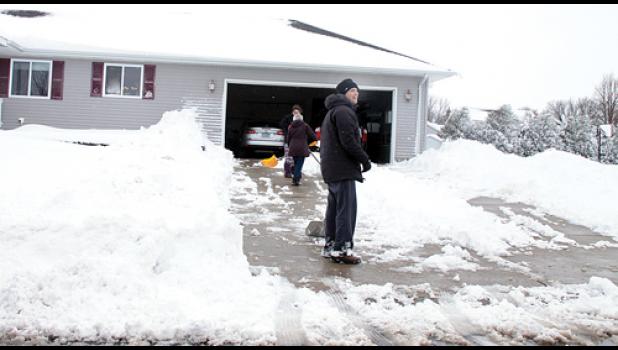 Staff Photo by Byron Higgin. Minneota Superintendent Dan Deitte and his family were out in their driveway right after Saturday’s storm in an attempt to get their cars out of the garage.