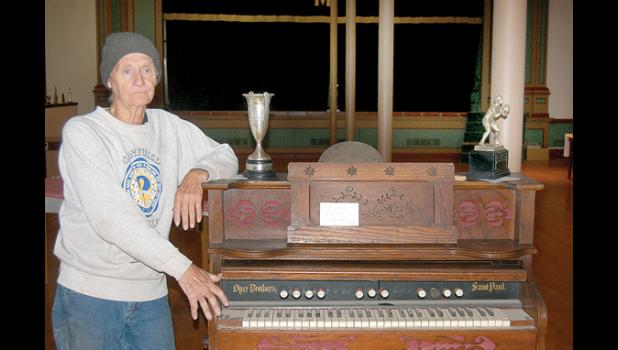 Staff Photo by Byron Higgin. Darren Gislason shows off one of the old organs in the Opera Hall in Minneota.