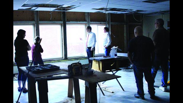Staff Photo by Byron Higgin. School board members including Dawn VanKeulen (left), Larry Buysse (third from right), Bill Bolt and Dan Longtin saw one of rooms in progress. Deitte said new windows will be installed. Most of the renovated area is also getting new LED lighting.