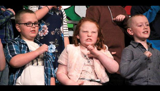 Staff photo by Byron Higgin. Singing “Nuttin’ for Christmas” were Third Graders (left to right) Mason Moorse, Imogen Moriarty, and Owen Myrvik.