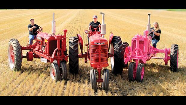 Special photo. Chad Nuese (left) on his tractor with step-son Ty on a tractor and Stacie on her pink tractor on the right.
