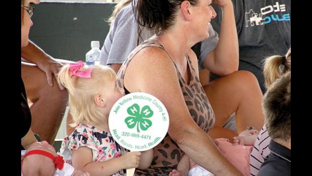 Staff Photo by Byron Higgin. It was a hot day and Ebony Petersen had a fan to try and stay cool with her grandmother Rhonda Weidert.