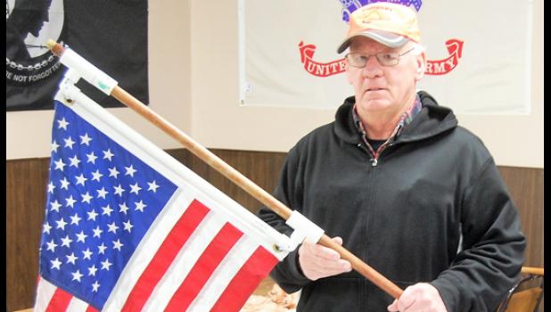 Mascot photo by Scott Thoma. Ed Lozinski shows a completed bracket that VFW members constructed out of PVC piping that reduces the wear and tear on a flag by allowing it to spin freely on the outside of a pole as opposed to wrapping around it.