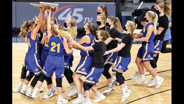 Mascot photo by Reba Lipinski The Minneota girls basketball team hoists the Class A state championship trophy after defeating Belgrade-Brooten-Elrosa 48-45 in the finals last Friday at Target Center.
