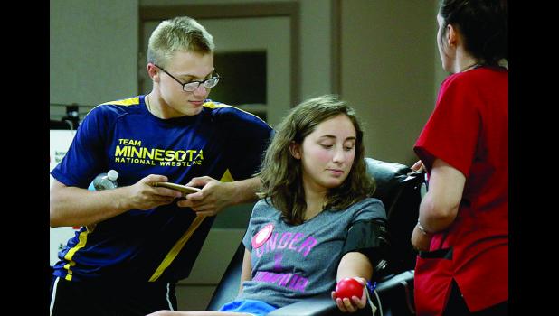 Staff Photo by Byron Higgin. It's summertime, so the amount of blood given isn't the same as in the winter. But Adiah Buysse gave blood at the Minneota American Legion this week as Bryce Bruner visite.