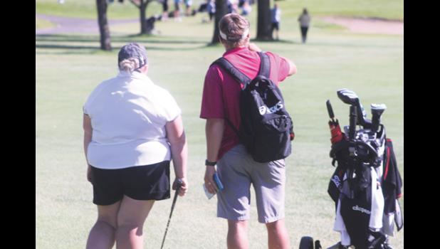 Mascot photo by Scott Thoma Lauren Bowyer talks with coach Walker Hennen on how to play her next shot during the state golf meet on Wednesday.