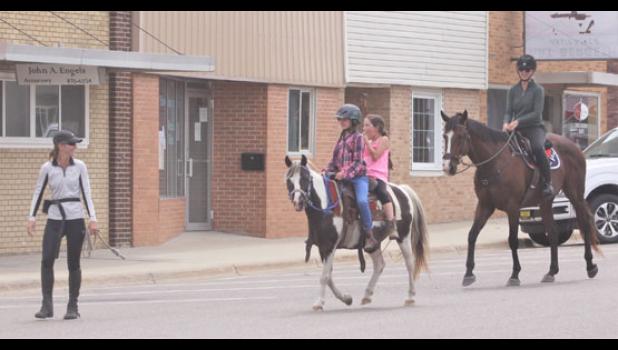 Mascot photo by Scott Thoma Krystal Howard, left, leads Half Pint with riders Charlotte Brusvig (front), 10, and Savanaah Brunsvig, 8, down main street of Minneota following the Silver Spurs event on Saturday. Following behing on Bentley is Kimberly Cochrane. Howard and Cochraner are trainers. The four girls rode from the Silver Spurs Saddle Club to get some ice cream on a hot day.