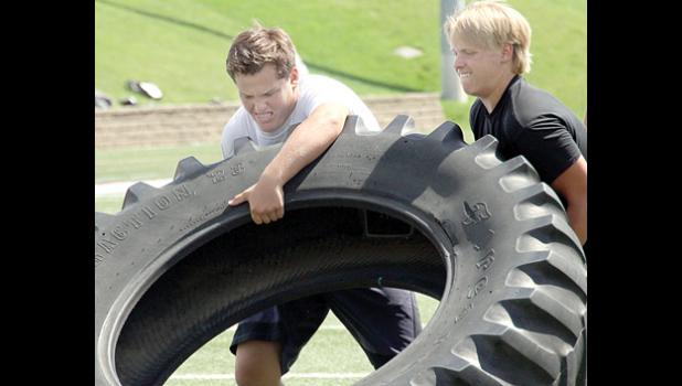 Staff Photo by Byron Higgin. Jackson Esping and Tyler Myhre push a tire.
