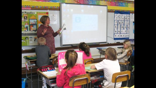 Special Photo. Julie Pohlen came to teach a Junior Achievement lesson to the first and second graders at St. Edward School.