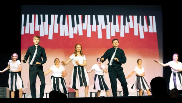 Photo for the Mascot by Brian Jeremiason. Here Jacob Haen, Natalie Bot and Jackson Jeremiason tap dance during the song, “I Love Piano.” They are supported by the ensemble dancers including (left to right) Kaitlyn Ludwikowski, Kimberly Bloch, Kathrin Walerius, Molly Krog and Tara Thooft.