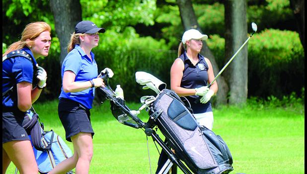 Staff Photo by Byron Higgin. Laura Knutson watched the flight of her ball (right).