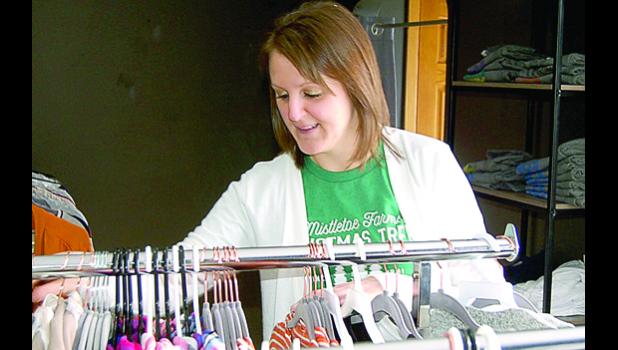 Staff photo by Scott Thoma. Jodi Maertens looks over the merchandise at her Rian & Jo Boutique north of Ghent.