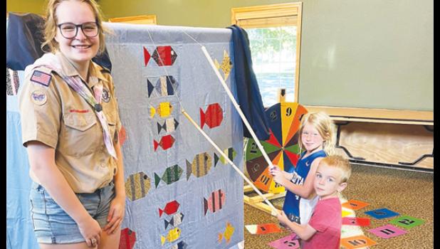 Contributed photo Ludwikowski stands beside one of the carnival games she made for her required community project.