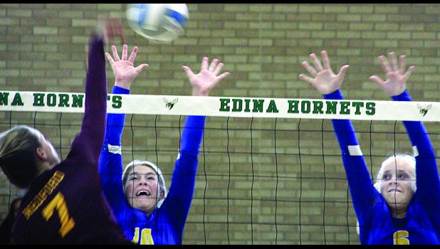 Staff Photo by Byron Higgin Morgan Hennen (left) strained to get a block against Medford. Abby Rost as also coming to help (right).