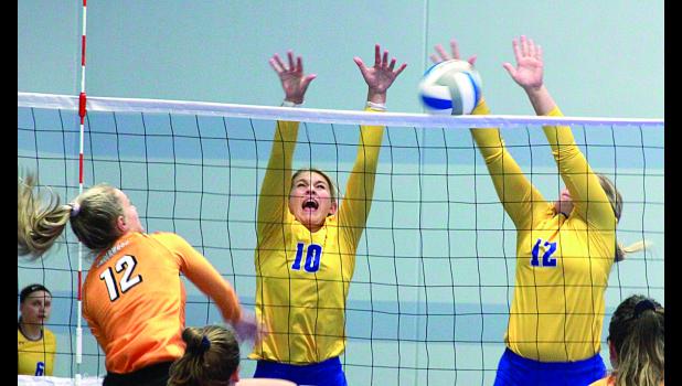 Staff Photo by Byron Higgin Morgan Hennen and Sydney Larson block the ball after a hit by an Underwood player.
