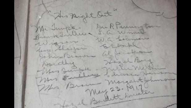 Staff photo by Scott Thoma. The entire cast and director of the play, “His Night Out,” signed an Opera Hall stage wall on May 23, 1917.