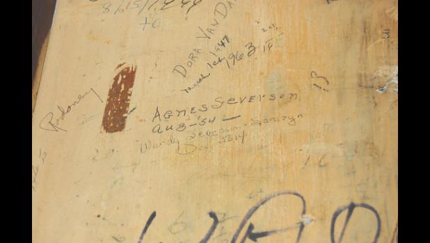 Mascot photo by Scott Thoma A wall inside the former Big Store (now the public library) elevator was signed by Agnes Severson in 1954 and then by her granddaughter Wendy Sarazyn 50 years later in 2014.