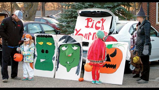 Staff Photo by Cherri Schmig. At the “Pick your nose” trunk was Seth Hennen and daughter Averi on the left. The trunk display was made by Shelly and Natalie Ratajczak (right).