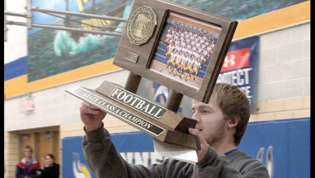 Staff Photo by Byron Higgin. Alex Pohlen, senior and a captain, brought the state championship trophy to the welcome home ceremony.
