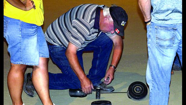 Staff Photo by Byron Higgin Measuring the distance between the Bolle and the pin is part of the event when two Bolle's appear to be about the same distance. Friday night one Boller got out his device to measure the distance.
