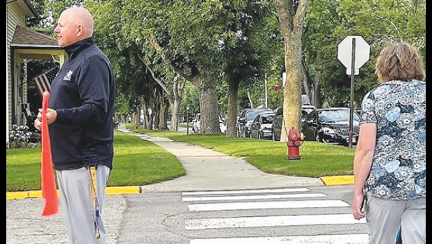 Contributed photo Superintendent Scott Monson stands guard at a crosswalk while a student and his grandmother cross.