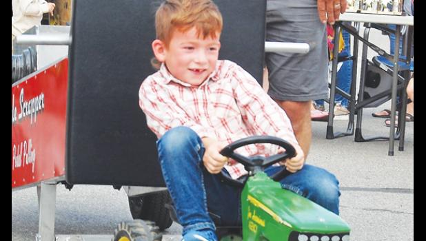 Mascot photo by Scott Thoma. Crosby Swedzinski of Ghent smiles as he competes in the Pedal Tractor pull.