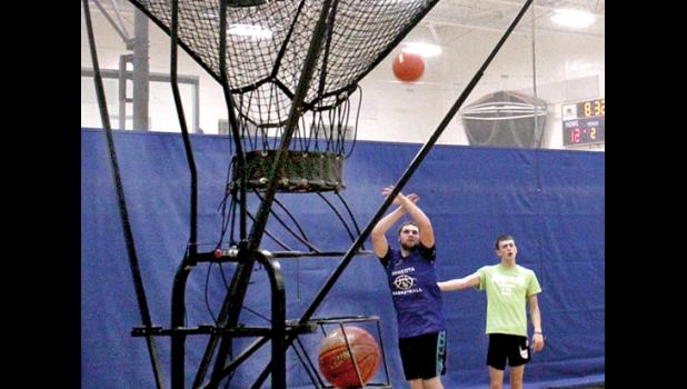 Staff Photo by Byron Higgin. Viking senior Grady Moorse took a shot with teammate Alex Saltzer watching.
