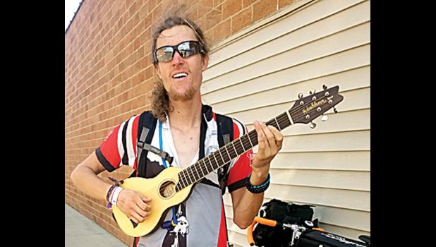 Staff photo by Brittany Moorse. Nikolaus Hasenfus showed off his traveling guitar and performed "Country Roads" at Brad's Market.