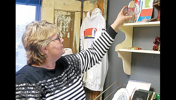 Staff Photo by Scott Thoma. Carla Thompson, the owner of Mary Louise, a vintage/antique store, stocks an item on a shelf during her Grand Opening ceremony that coincided with Small Business Saturday.