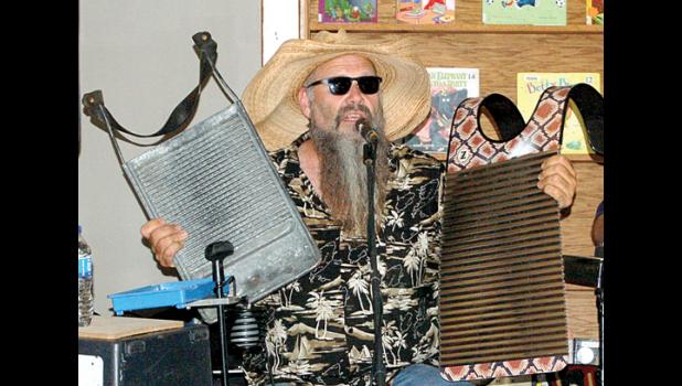 Staff photo by Hannah Buysse. Smithson shows a washboard that is 100 years old and made for washing clothes (left) and another one that is newer and designed for music (right).