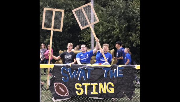 Special photo. The famous green couch with its legs (inset) at the Homecoming game with seniors Kyle Banks, Gared Moorse and Riley Yost ready to “Swat the Sting.”