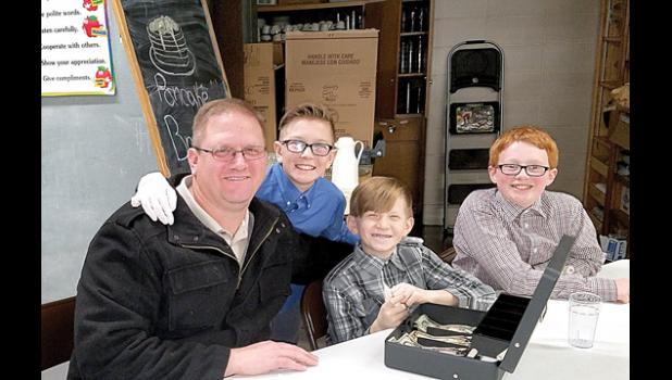 Staff photo by Cherri Schmig. Jason Myhre, son Ian and nephew Sam Myhre and Wyatt Pohlen took the money at the pancake feed.