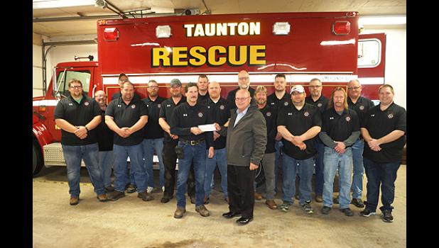 Photo for the Mascot by Sue Jacobson. The Taunton Fire Department accepted a check from State Bank of Taunton President Duane Peterson in front of their new rescue truck.
