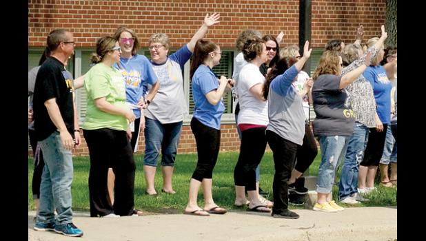Photo for the Mascot by Sue Jacobson. Teachers waved to the students as they left for the summer and students on the buses waved to their teachers.