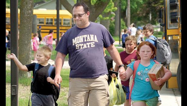 Photo for the Mascot by Sue Jacobson. Walking his kids Imogen and Padraic home from the last day of school was David Moriarty. Padraic waved as he left school for the final time this year.
