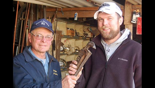 Staff photo by Scott Thoma. Wayne Wyffels (left) and the “Passing of the Wrench,” to Brian Kloos.