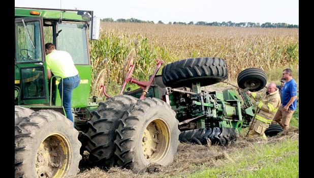 Staff Photo by Byron Higgin Workers attached the Skaar tractor to another one to get it uprighted.