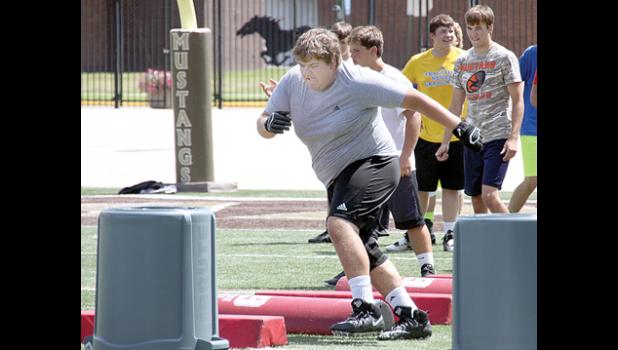 Staff Photo by Byron Higgin. Zach Van Keulen weaves during football camp.