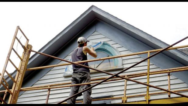Photos for the Mascot by Sue Jacobson. Timothy Merwin pulled tape off after the window was painted.