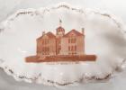 This white china souvenir dish with a photograph of the School of Minneota, Minn. on the inside in among the collection items at the Lyon County Museum in Marshall. The dish also has a gold pattern around the rim and “Weimar, Germany” is printed on the bottom.